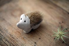 a small toy hedgehog sitting on top of a wooden table