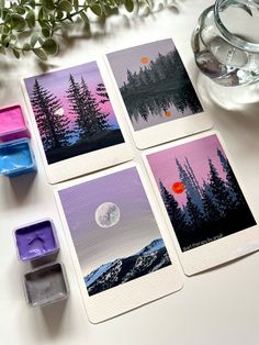 four cards with trees on them next to some wax cubes and a glass vase