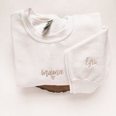 "Custom Embroidered Mama Sweatshirt for Mom with Name on Sleeve, Personalized Gift for Mom with Name On Sleeve, Embroidered Sweater for Mama Introducing our one-of-a-kind custom mama embroidered sweatshirt! Embroidered to perfection, this stylish sweatshirt is the perfect addition to any mama's wardrobe. The machine-embroidered neckline adds a touch of elegance to this already unique piece, while the custom sleeve embroidery details make it truly one-of-a-kind. Crafted with care and attention to White Letter Embroidery Sweatshirt For Loungewear, White Sweatshirt With Letter Embroidery For Loungewear, Custom Embroidered White Tops For Mother's Day, Family Matching Embroidered Long Sleeve Sweatshirt, Family Matching White Sweatshirt With Letter Embroidery, White Family Matching Sweatshirt With Letter Embroidery, Long Sleeve Sweatshirt With Embroidered Logo Gift, Embroidered Logo Sweatshirt As A Gift, White Fleece Top With Custom Embroidery