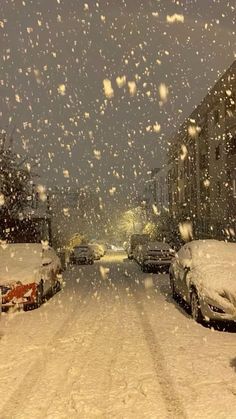 cars parked on the side of a snow covered street