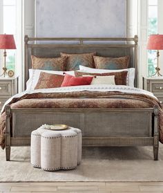 a bedroom with a bed, nightstands and two lamps on either side of the bed