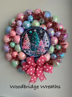 a christmas wreath with ornaments and pink bows