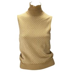 Presenting a beige Gucci mock neck sweater vest, designed by Tom Ford. From the Fall/Winter 2000 collection, this beautiful sweater vest is ribbed and features a square Gucci 'G' pattern at the front. The same square 'G's were used in a photoshoot by Andres Serrano. A fabulous piece of Gucci by Tom Ford, this chic sweater is the perfect addition to any wardrobe or collection! Chic Gucci Luxury Tops, Luxury Sleeveless Gucci Tops, Elegant High Neck Sweater Vest For Fall, Fitted Beige Sweater Vest, Fitted Elegant Beige Sweater Vest, Elegant Fitted Beige Sweater Vest, Gucci Cardigan, Gucci By Tom Ford, Vintage Blouses