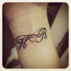 a small wrist tattoo with the letter p on it's left side, and a heart in the middle