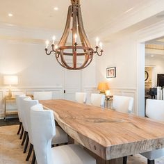 a large wooden table surrounded by white chairs