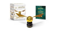 a harry potter golden snitch figure next to an unopened box