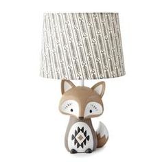 a little fox lamp with a fabric shade on it's head, sitting in front of a white background