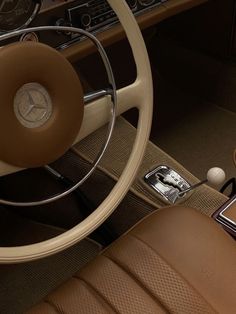 the interior of a car with brown leather seats and steering wheel, including an electronic device