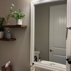 a bathroom with a sink, mirror and shelf above the bathtub is shown in this image