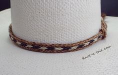 BOLD DESIGNED Horsehair bat band Cinnamon brown, black and Ivory white horsehair trimmed with a larger, cinnamon brown side matching horsehair tassel. HIGHLY NOTICEABLE, especially light colored hat. adds such a Fancy aspect to the Western design. Unique, distinctive and exceptional quality Everything you want in a Horsehair hat band. Brings out your spirit in an exclusive design that is vibrant as your western lifestyle. MEASUREMENTS * Longest length 25 inches * Shortest length about 15 inches White Straw Hat For Ranch, White Straw Hat With Short Brim For Ranch, White Brimmed Straw Hat For Ranch, White Fedora Panama Hat For Ranch, White Adjustable Panama Hat For Western-themed Events, White Short Brim Straw Hat For Western-themed Events, White Brimmed Straw Hat For Western-themed Events, White Fedora Straw Hat For Country Events, White Country Style Fedora Straw Hat