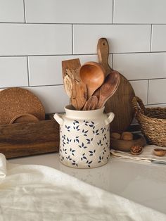 wooden utensils and spoons in a ceramic pot on a counter