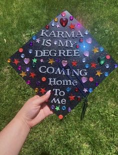 someone is holding up a graduation cap that says, karma is my degree coming home to me