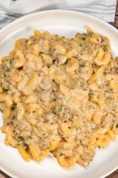 a white plate topped with macaroni and cheese covered in mushroom gravy