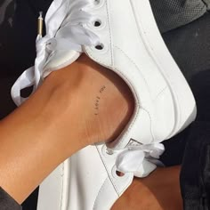 a person's foot with a small tattoo on the left side of their shoe