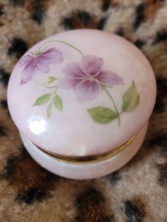 a pink flowered box sitting on top of a leopard print surface