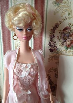 a doll with blonde hair wearing a pink dress