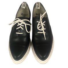 Women's Dr. Martens Camille Oxford Shoes. These Cute And Dapper 4-Eye Lace-Up Black Leather Oxford Shoes Are Timeless, And Feature A Genuine Leather Upper, A Leather And Textile Lining, And Chunky Whitewall Non-Slip Rubber Soles. With A Pointed Toe Style And A 1" Platform Heel. Has A Striking Black And White Contrast. With An Air Cushioned Sole Known As "Air Wair" Bouncing Soles. These Shoes Are Oil, Fat, Alkali, Gas And Acid Resistant. Size 9. Please Note There Is Some Light Markings On The Whitewall Soles, But These Shoes Are Otherwise In Great Preowned Condition. All Offers Considered And Appreciated. Black And White Contrast, Black Oxford Shoes, Black Leather Oxfords, Oxfords Shoes, Black Oxfords, Leather Oxford Shoes, Platform Heel, Platform Heels, Flat Shoes Women