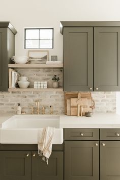 a kitchen with gray cabinets and white counter tops