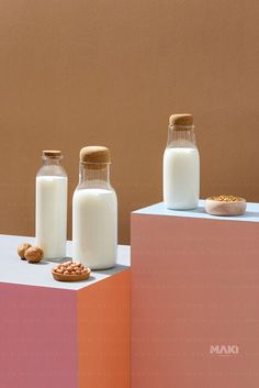 milk and cookies are sitting on top of two blocks, one is pink and the other is orange