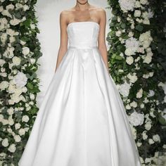 a woman in a white wedding dress on the runway