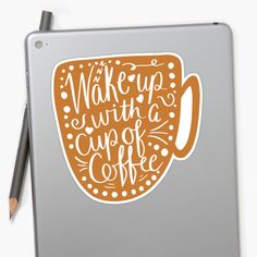 a laptop with a sticker on it that says wake up with a cup of coffee