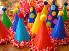 colorful party hats with pom poms and streamers on the floor at a children's birthday party