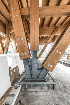 the inside of a building with wooden beams and metal piping on it's sides