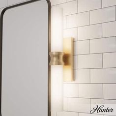 a bathroom with a white tiled wall and a gold framed mirror on the wall next to it