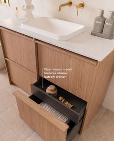 a bathroom sink sitting under a mirror next to a wooden cabinet with drawers underneath it