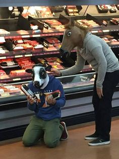 a woman is petting a cow in the store while another person looks at it