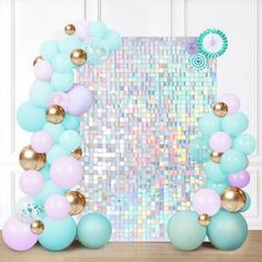 the balloon arch is decorated with pastel colors and gold accents, along with balloons