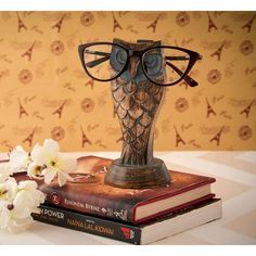 an owl figurine with glasses on top of two books