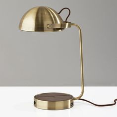 a lamp that is on top of a white table with a brown cord attached to it