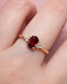 a woman's hand with a red and white diamond ring on it