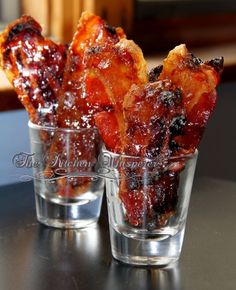 three glasses filled with food sitting on top of a black table next to each other