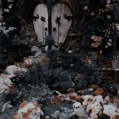 an old door surrounded by flowers and plants