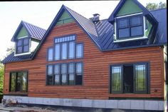 a large wooden house with windows on the roof