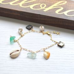 "This beautiful ocean inspired charm bracelet has an assortment of shells and cultured sea glass dangling from a textured cable chain and finished with a tiny gold filled starfish at the end. This bracelet is meant to dangle so I add 1/2\" to the length you order. Please allow for variations in size and shape of shells and sea glass." Pearl Bangles Gold, Beachy Bracelets, Pearl Bangle Bracelet, Sea Glass Bracelet, Pearl Bangle, Puka Shell, Shell Bracelet, Beautiful Ocean, Glass Bracelet