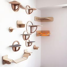 several wooden shelves on the wall with different shapes and sizes, hanging from each shelf