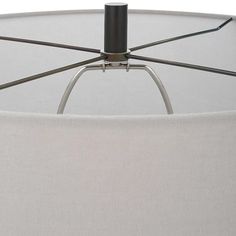 a lamp that is on top of a white table cloth with a black metal pole