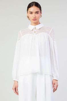 A lace paneled yoke accents this floaty blouse designed with a classic collar at the neck. It's relaxed and airy, enhanced by subtle gathers that create a beautiful drape. •Collared neckline •Button closure •Long sleeves •Elasticized cuffs •Relaxed fit Item number 2430145100% Polyester White Blouse With Smocked Bodice For Daywear, White Lace Collar Top For Work, White Blouse With Lace Sleeves For Work, Chic Collared Lace Top Blouse, Feminine Lace Top With Lace Cuffs For Daywear, White Lace Collar Top For Daywear, Chic Collared Blouse With Lace Trim, White Lace Cuffs Blouse For Work, White Feminine Blouse With Sheer Sleeves