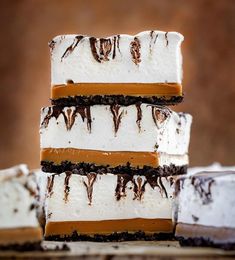 four pieces of cake stacked on top of each other with chocolate and marshmallows