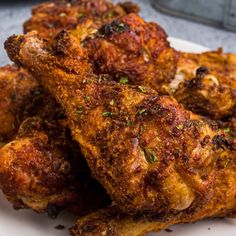 some fried food on a white plate with seasoning sprinkled around it's edges