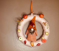 a stuffed animal hanging on the wall in front of a wreath with fruit and vegetables around it