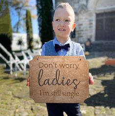 a young boy holding up a sign that says don't worry ladies i'm still single