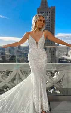 a woman in a white wedding dress posing for the camera with her arms outstretched out