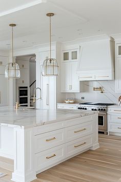 a large kitchen with white cabinets and marble counter tops, an island in the middle