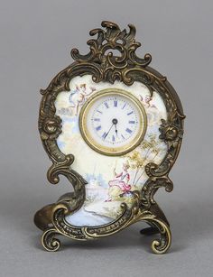 an ornate clock with floral designs on the front and sides, sitting on a stand