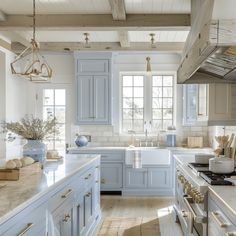 a large kitchen with blue cabinets and white counter tops, along with wooden flooring