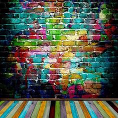 an abstract brick wall painted with multicolored paint and wooden floor in front of it